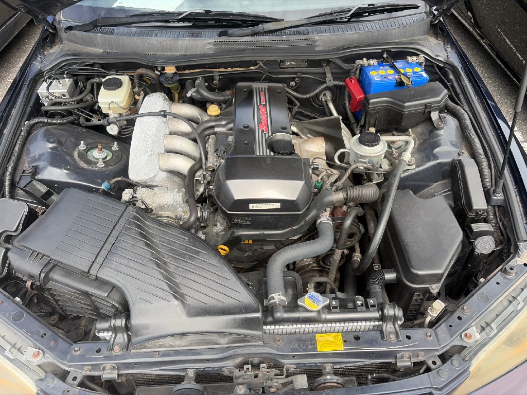 Engine bay of a Toyota Altezza 3S-GE Beams engine with blue battery and stock intake