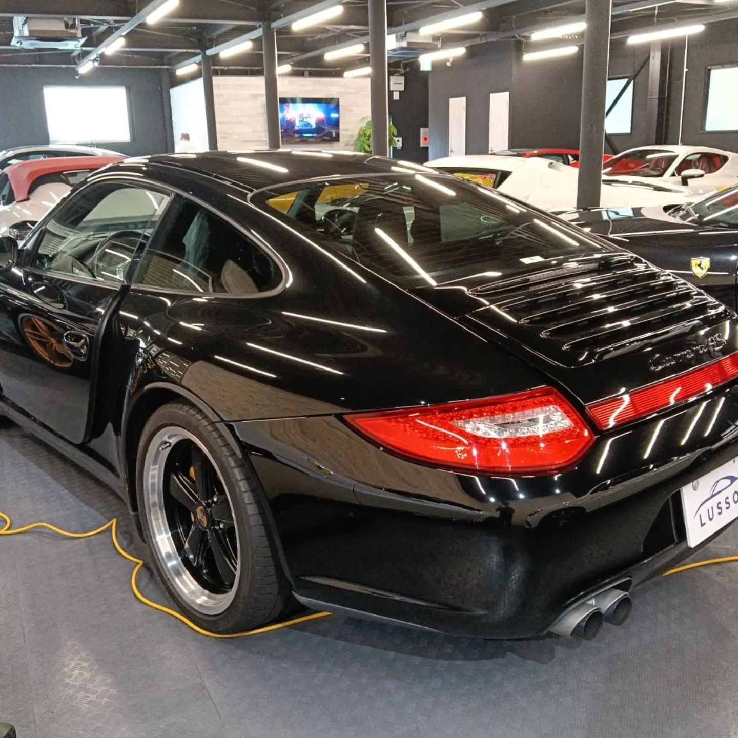 Black Porsche 911 997 Carrera 4S rear three-quarter view after July import